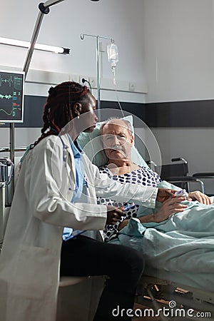 Unwell senior patient laying in bed breathing through oxygen test tube Stock Photo