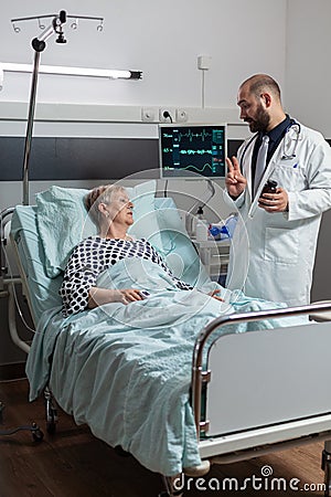 Unwell senior woman patient laying in hospital bed Stock Photo