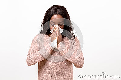 Unwell young woman blowing her nose Stock Photo