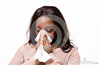 Unwell young woman blowing her nose Stock Photo