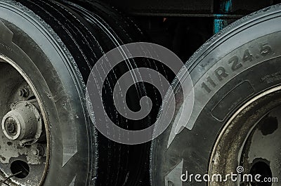 Up close to the tires of a cargo truck, black tires with dirt caused by rain in a city Stock Photo