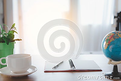 Up of coffee on the table, Wood office desk table With a notepad, pen and coffee, Behind the window is the light entering ,Work fo Stock Photo