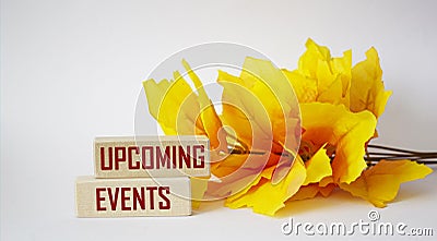 Upcoming events concept office desk with orange branch. Upcoming events text written on wooden blocks Stock Photo