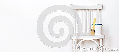 Upcycling concept. Repainting an retro chair. Old white wooden chair against white wall. Banner format Stock Photo