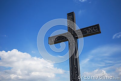 Uplifted christian cross on a blue cloudy sky Stock Photo