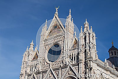 Upper facade detail of Duomo di Siena or Metropolitan Cathedral of Santa Maria Assunta. Tuscany. Italy. Editorial Stock Photo