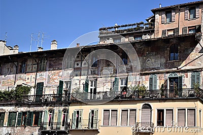 Upper part of the frescoed and sunlit facades of ancient buildings in Piazza delle Erbe in Verona. Editorial Stock Photo