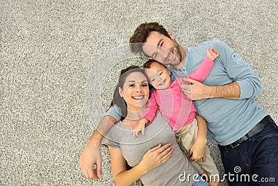 Upper view of family of three laying on carpet floor Stock Photo