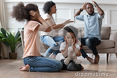 Upset african kids closing ears hurt by parents fighting Stock Photo