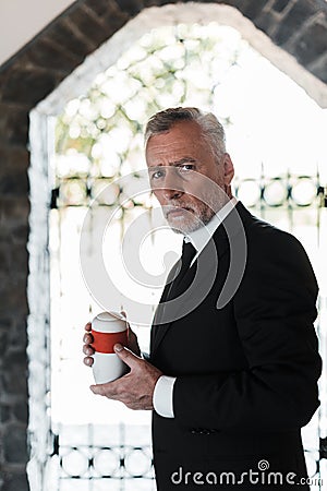 Bearded elderly man holding mortuary urn Stock Photo