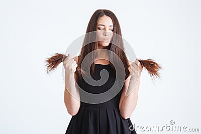 Upset beautiful woman looking on splitting ends of long hair Stock Photo