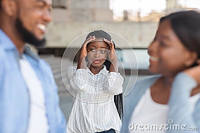 Upset black woman watching her boyfriend flirting with other girl outdoors Stock Photo