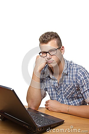 Upset and bored boy sitting in front of his laptop Stock Photo