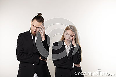 Upset business couple wearing black suits over white background, working together Stock Photo