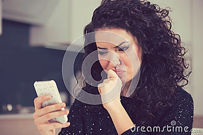 Upset confused young woman looking at mobile phone reading text message Stock Photo