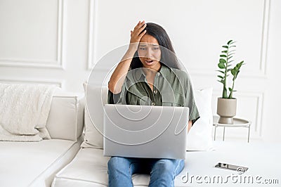 Upset and frustrated young indian woman using laptop for remote work from home Stock Photo