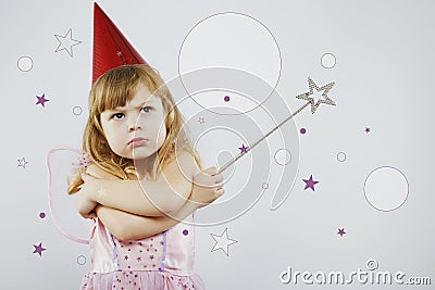 Upset girl with silver magic stick in studio Stock Photo
