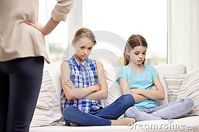 Upset guilty little girls sitting on sofa at home Stock Photo