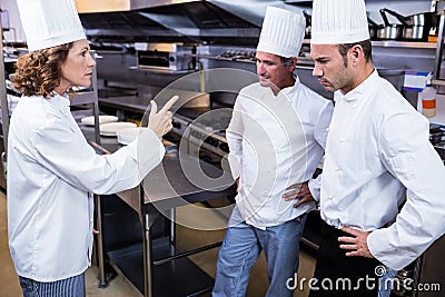 Upset head chef talking to her team Stock Photo