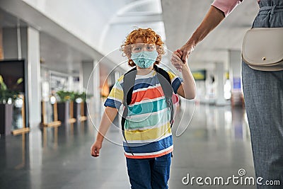 Upset kid with backpack holding a hand Stock Photo