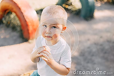 upset little baby boy outdoors infant portrait pain blanket park, ice-cream in hands Stock Photo