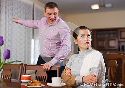 Upset man and frustrated woman arguing at home Stock Photo
