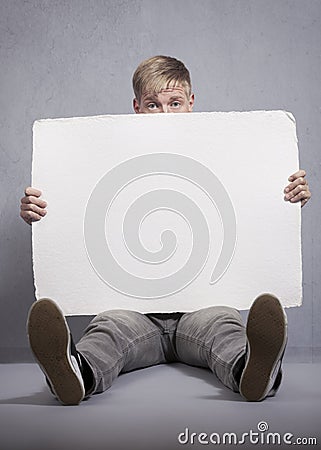 Upset man holding white empty panel. Stock Photo
