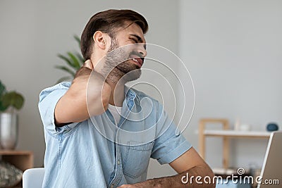 Upset man in pain touching stiff neck suffering from fibromyalgia Stock Photo