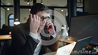 Upset manager speaking cell overwork in office. Stressed trader check computer Stock Photo