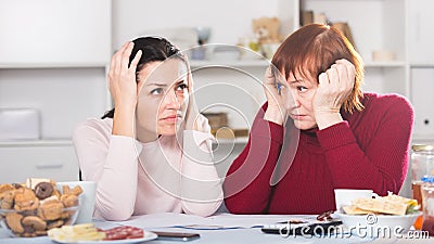 Upset mature woman and daughter with papers Stock Photo