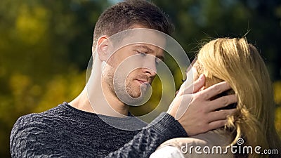 Upset man looking at woman and touching her face, lack of money, unemployment Stock Photo