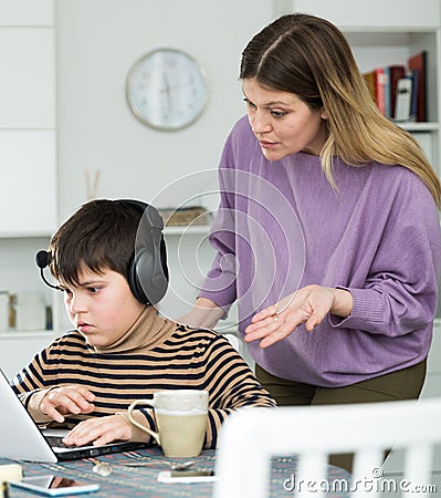 Upset mother arguing with son who plaing video games Stock Photo