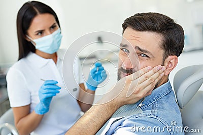 Upset Patient Touching Face While Having Toothache Near Dentist Royalty
