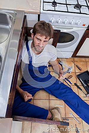 Upset plumber trying to fix the sink Stock Photo