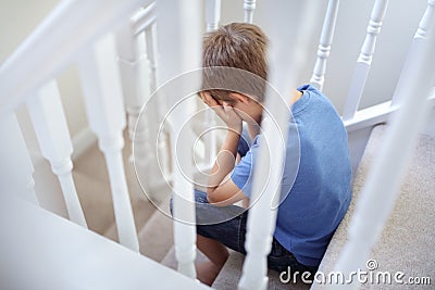 Upset problem child sitting on stairs Stock Photo