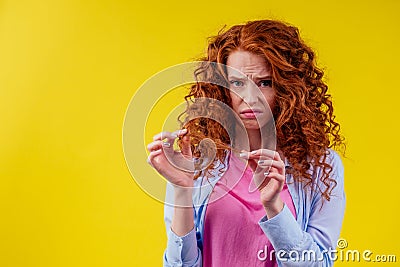 Upset redhaired ginger foxy woman with dryness tangled red hair Stock Photo