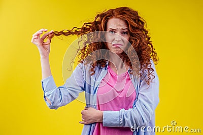 Upset redhaired ginger foxy woman with dryness tangled red hair Stock Photo