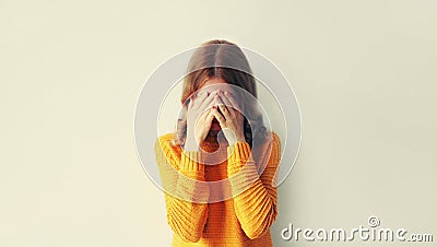Upset sad crying woman covering her eyes with her hands while experiencing mental or physical suffering Stock Photo