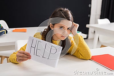 Upset schoolgirl holding paper with help Stock Photo