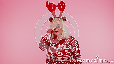 Upset senior Christmas old woman making face palm gesture, feeling bored, disappointed, bad result Stock Photo