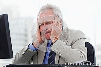 Upset senior manager working with a monitor Stock Photo