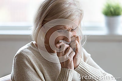 Upset aged woman crying at home feeling unwell or lonely Stock Photo