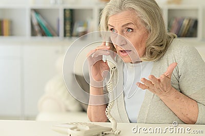Upset senior woman with phone Stock Photo