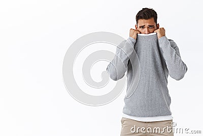 Upset silly and timid young cute gay feeling offended and lonely, pulling sweater collar on face, frowning upset and Stock Photo