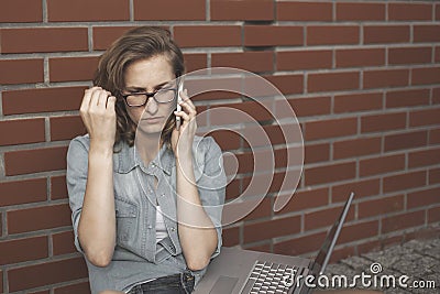 Upset student wornikg with laptop, thinking of something. Sitti Stock Photo