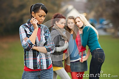 Upset Teenage Girl With Friends Gossiping Stock Photo