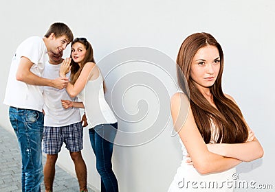 Upset teenage girl with friends gossiping Stock Photo