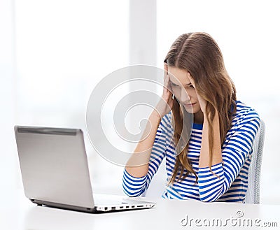 Upset teenage gitl with laptop computer at home Stock Photo