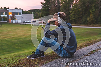 Upset teenager sitting on the ground. Stock Photo