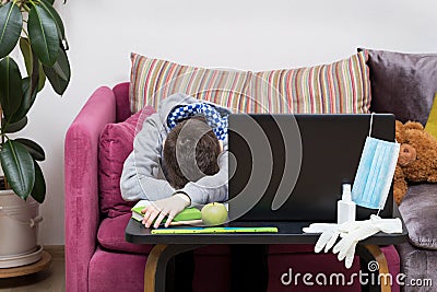 Upset and tired boy has online lesson at home during the quarantine Stock Photo